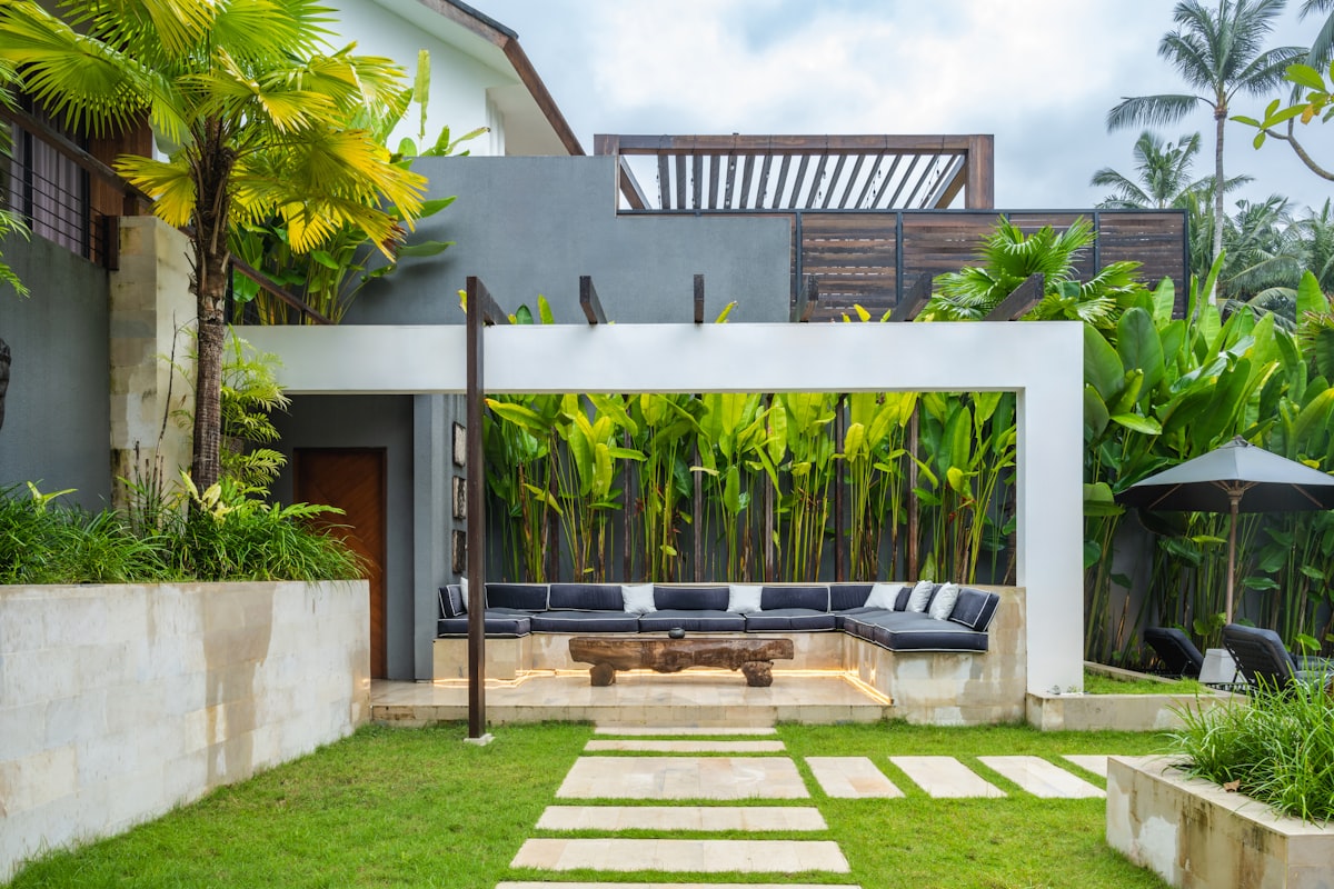 Natural stone steppers lead across turf to a lounge area — rooftop-friendly design.