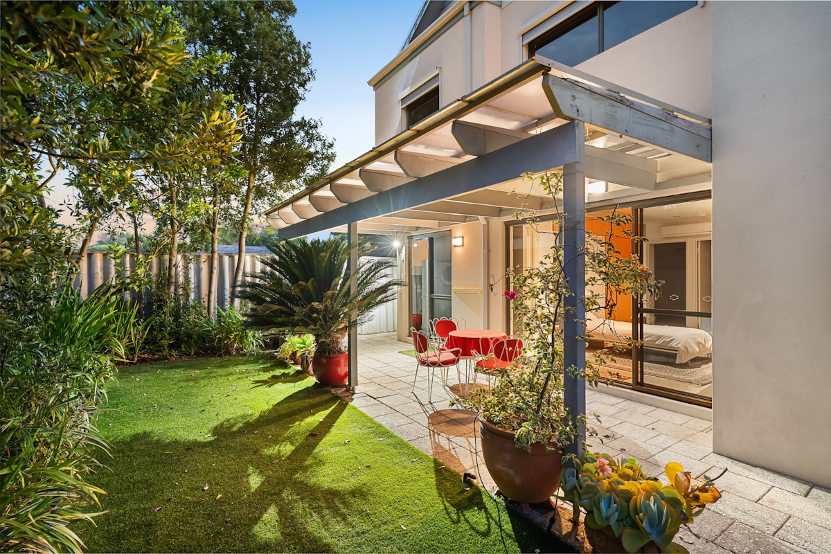 Al fresco dining surrounded by synthetic grass — pets and kids play while adults relax.