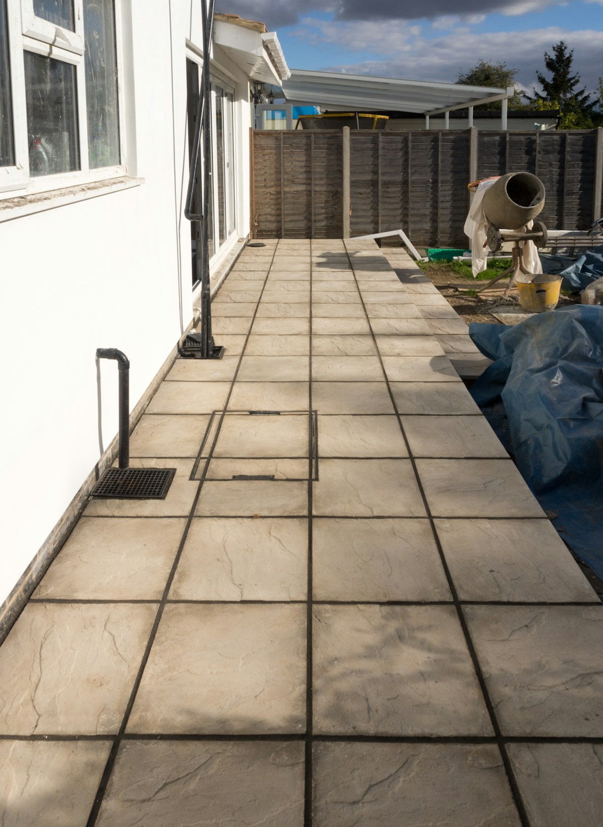 Porcelain patio tiles meet artificial grass at a clean seam — no weeding, no mud transfer.