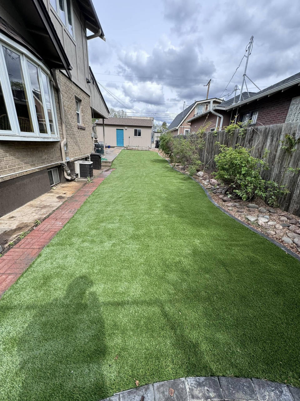 Backyard artificial turf lawn with a brick walkway — artificial turf in Denver, CO
