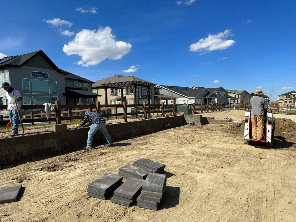 Crew building a retaining wall before turf installation — artificial turf in Parker, CO
