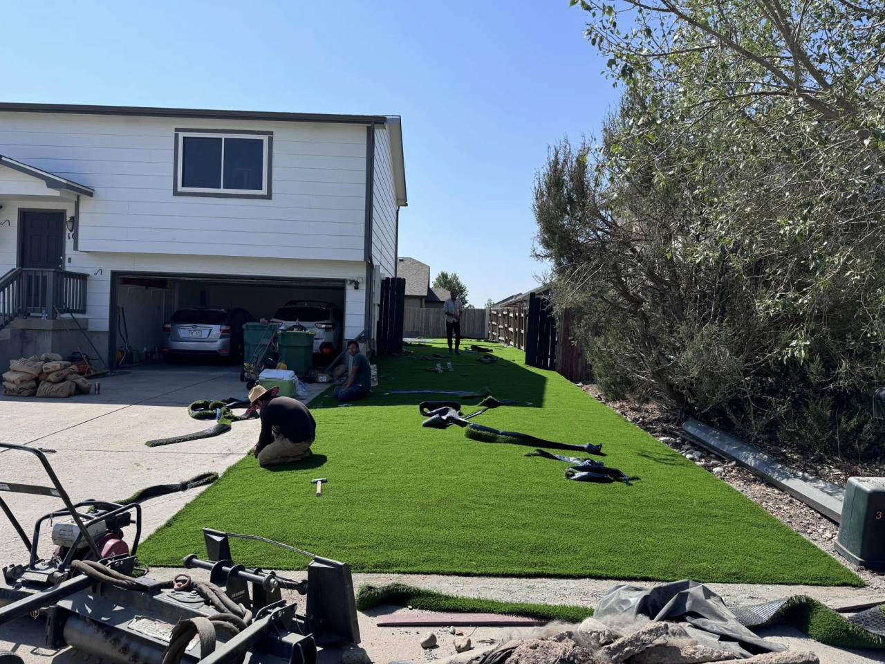 Crew installing artificial turf rolls on a front lawn — artificial turf in Centennial, CO