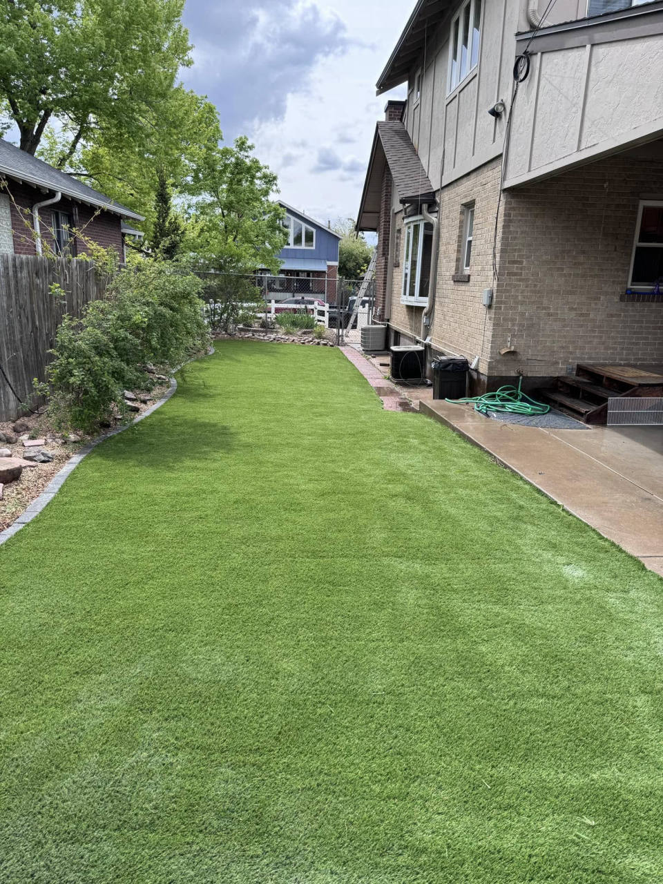 Side-yard synthetic grass lawn next to a Denver-area home — artificial turf in Denver, CO